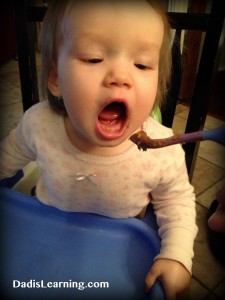baby eating chocolate pudding